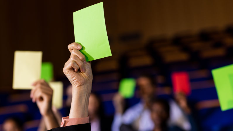 business executives show their approval by raising hands