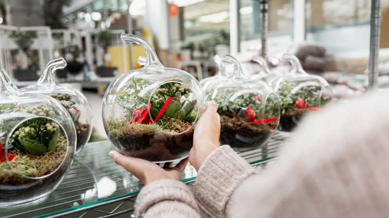 florist holding transparent globe shaped vase