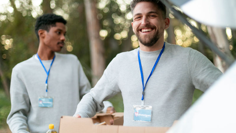 medium shot volunteers carrying boxes